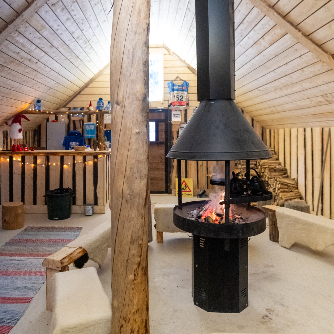Cozy wooden kota with an open fire pit at the husky farm