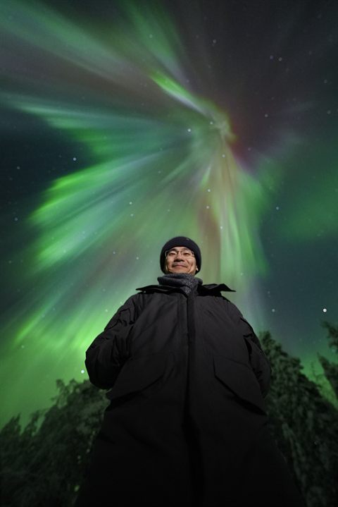 Ospite sotto una corona di aurora che riempie il cielo