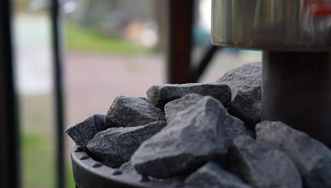 Nahaufnahme heißer Saunasteine auf dem Holzofen im Glasiglu