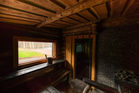 Wooden Finnish sauna with a window over the lake