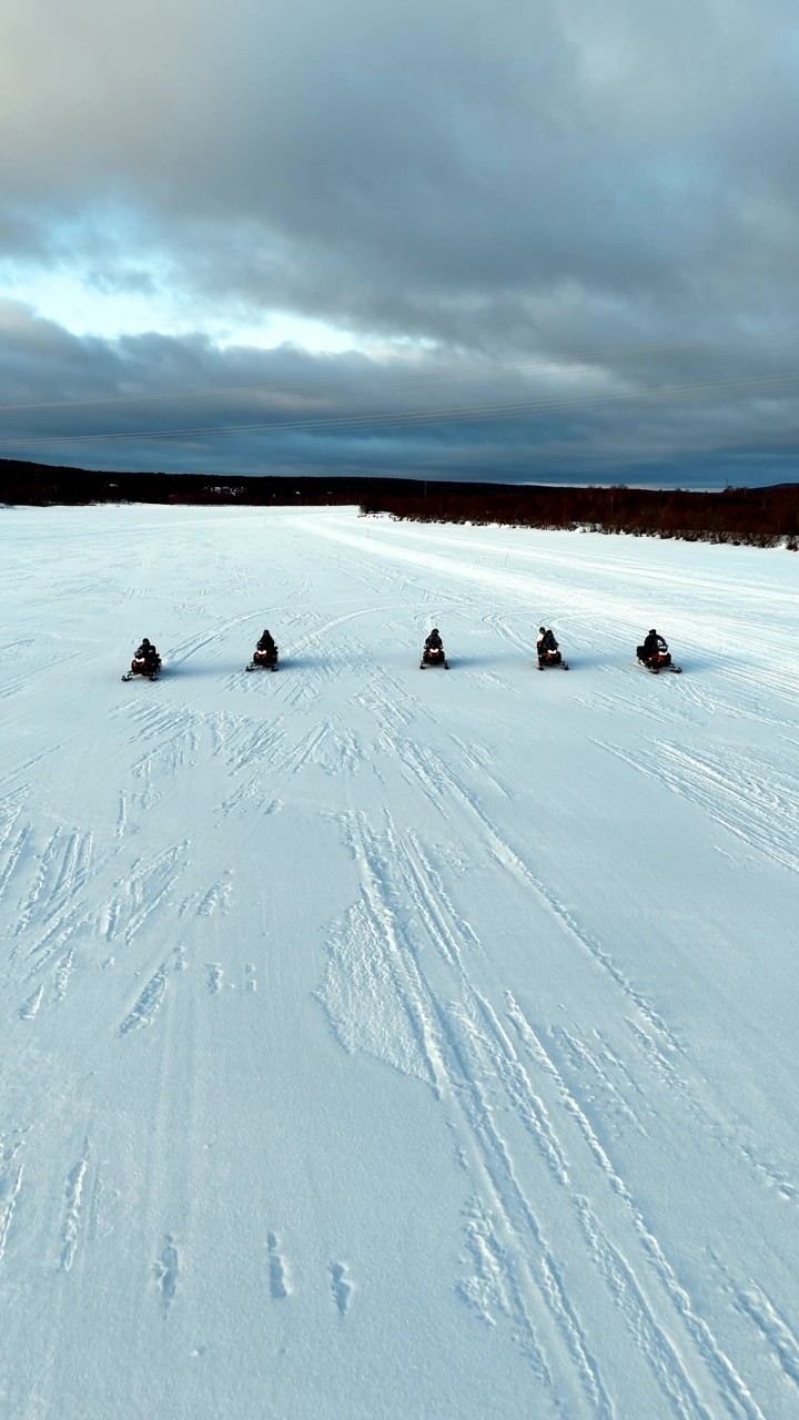 Snowmobile group riding on a frozen lake